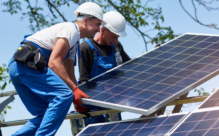 two workmen fitting a solar panel