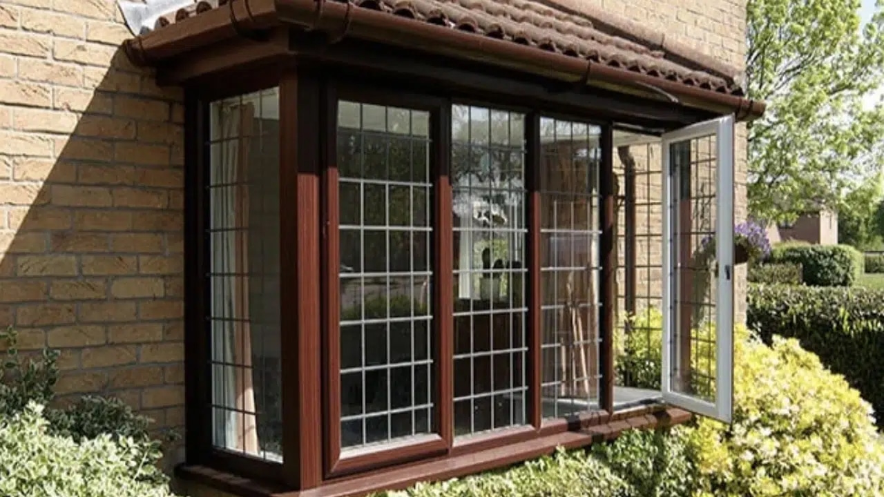 uPVC bay window in dark wood grain with a white interior. (Image credit: Anglian)
