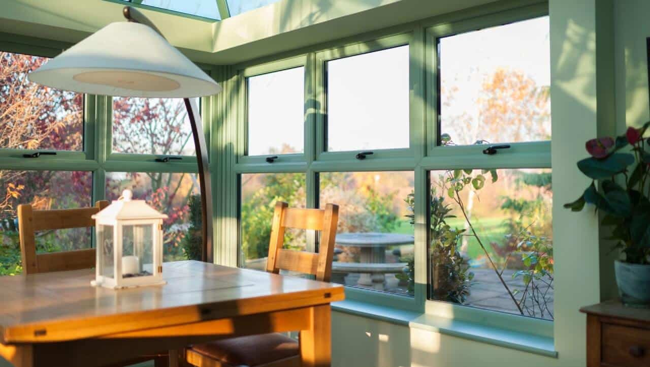 Britannia double glazing windows in green installed in a bright and airy conservatory