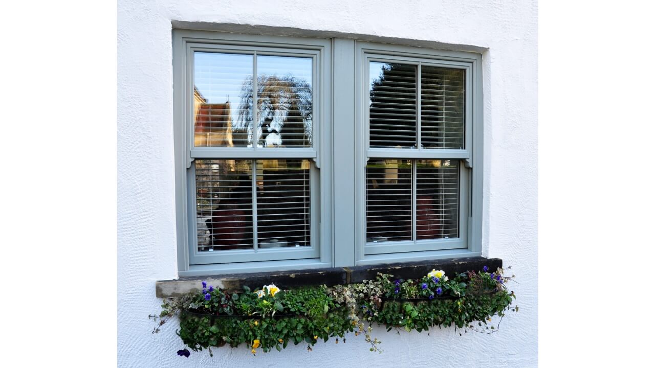 Britannia double glazing windows in Chartwell green with a flower box underneath