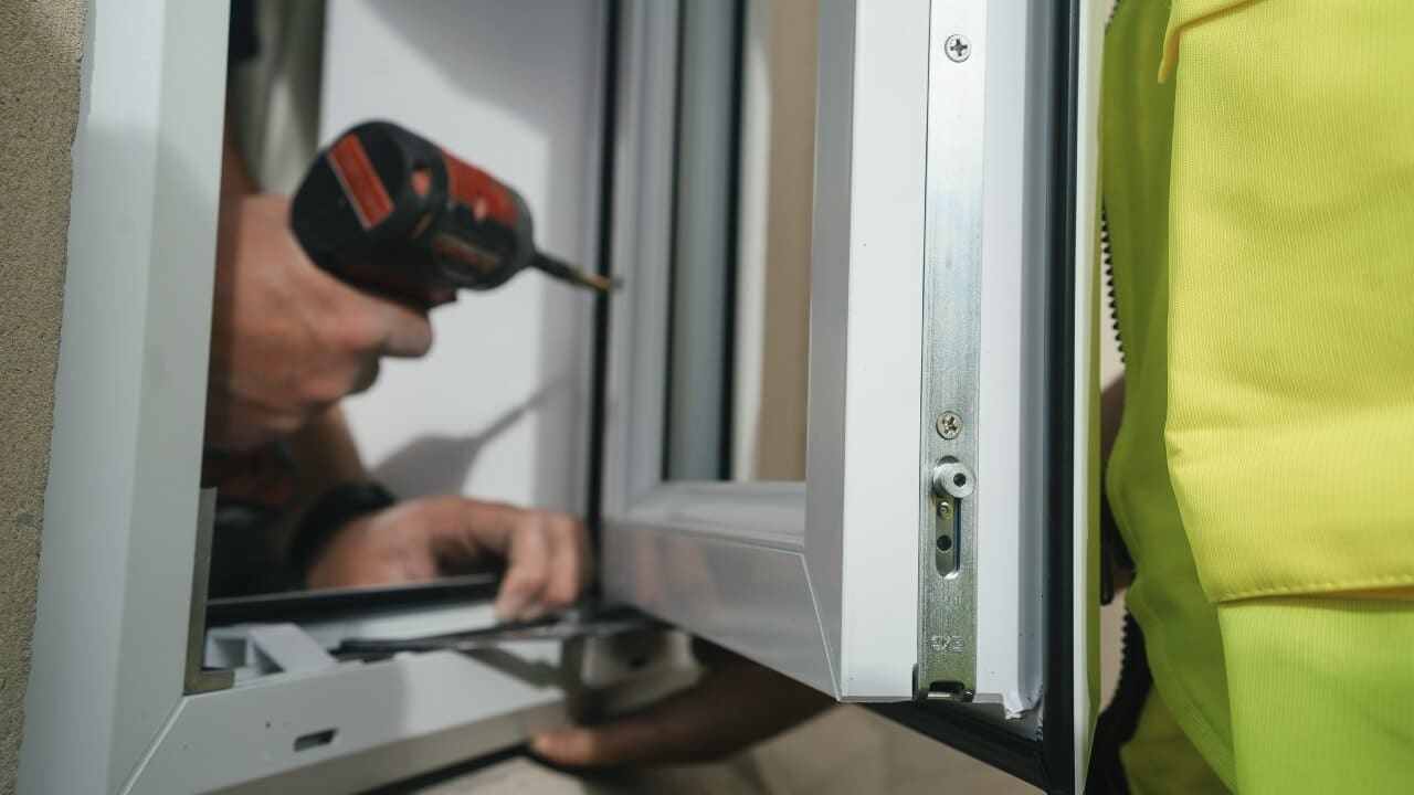 How much do double glazing windows cost? Two people installing a double glazing window in a house