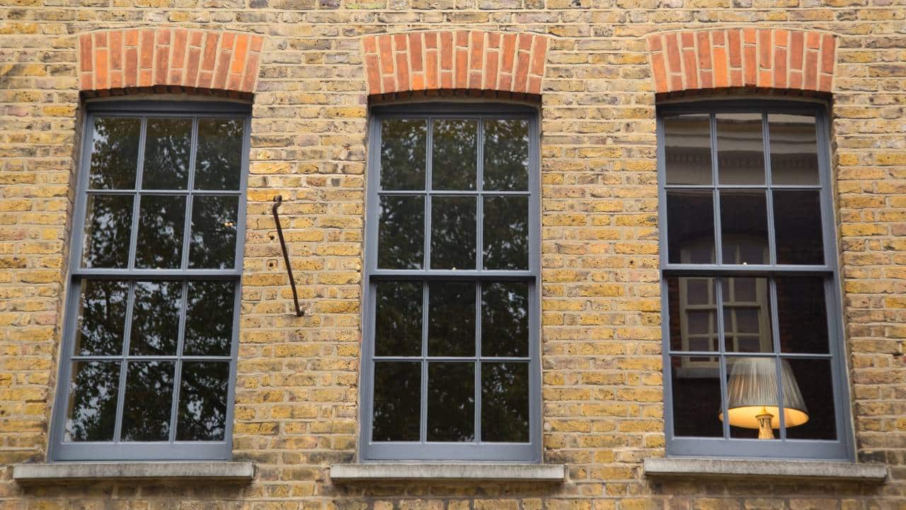 clack painted sash windows in brick building