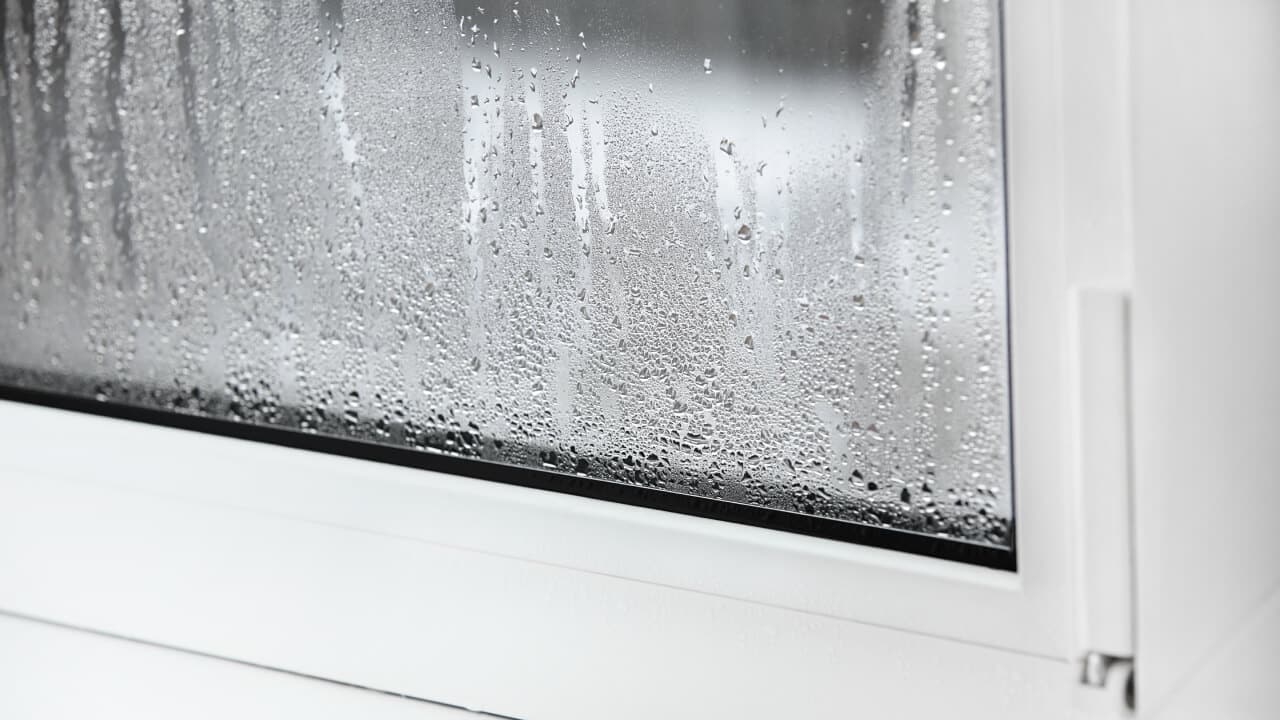A white uPVC window with condensation on the glass.