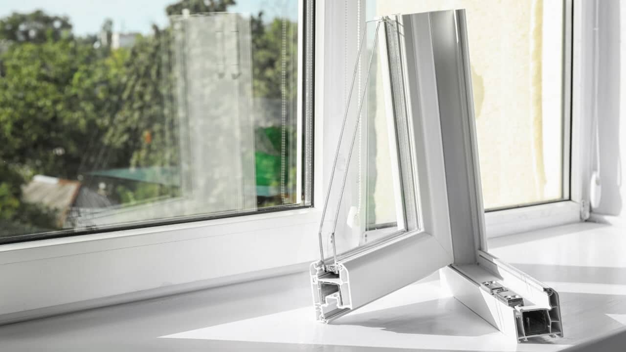 A cross section of a white uPVC window with double glazing sitting on a window frame to show how uPVC windows are made..