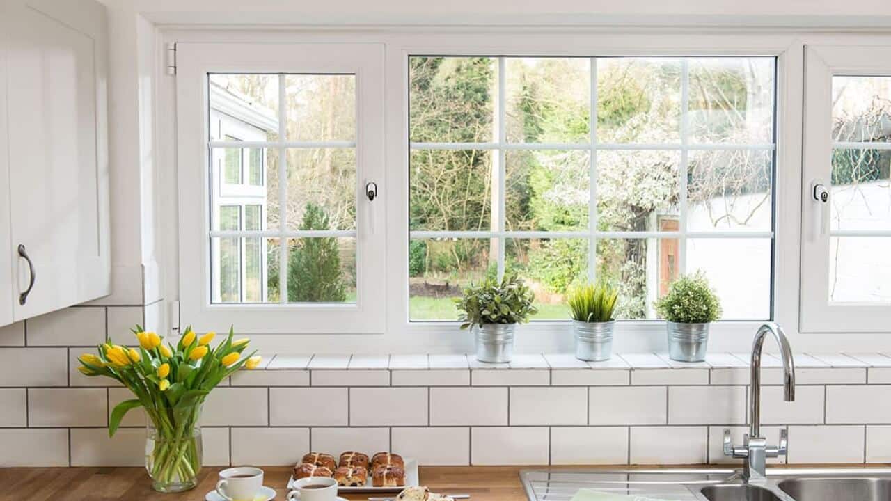 Anglian vs Everest. A white uPVC casement window with Georgian bars by Everest in a white kitchen.