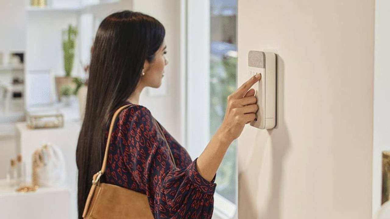 woman pushing home security keypad as leaving home