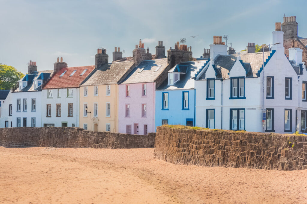 A colourful row of seaside houses on the sandy beach of the quaint coastal fishing village of Anstruther, East Neuk, Fife, Scotland, UK on a sunny summer day.